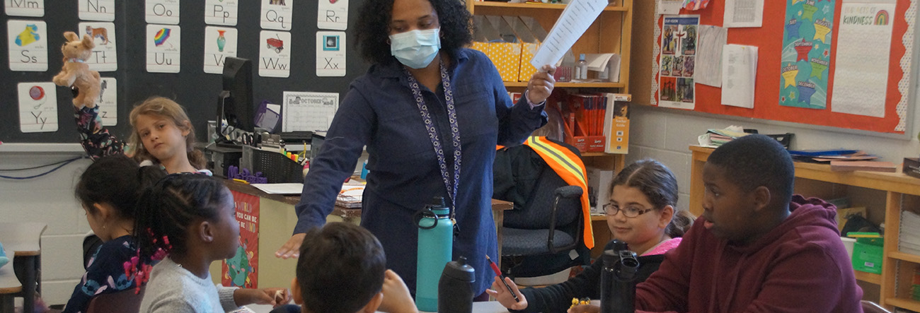Female educator wearing a masking and talking to students